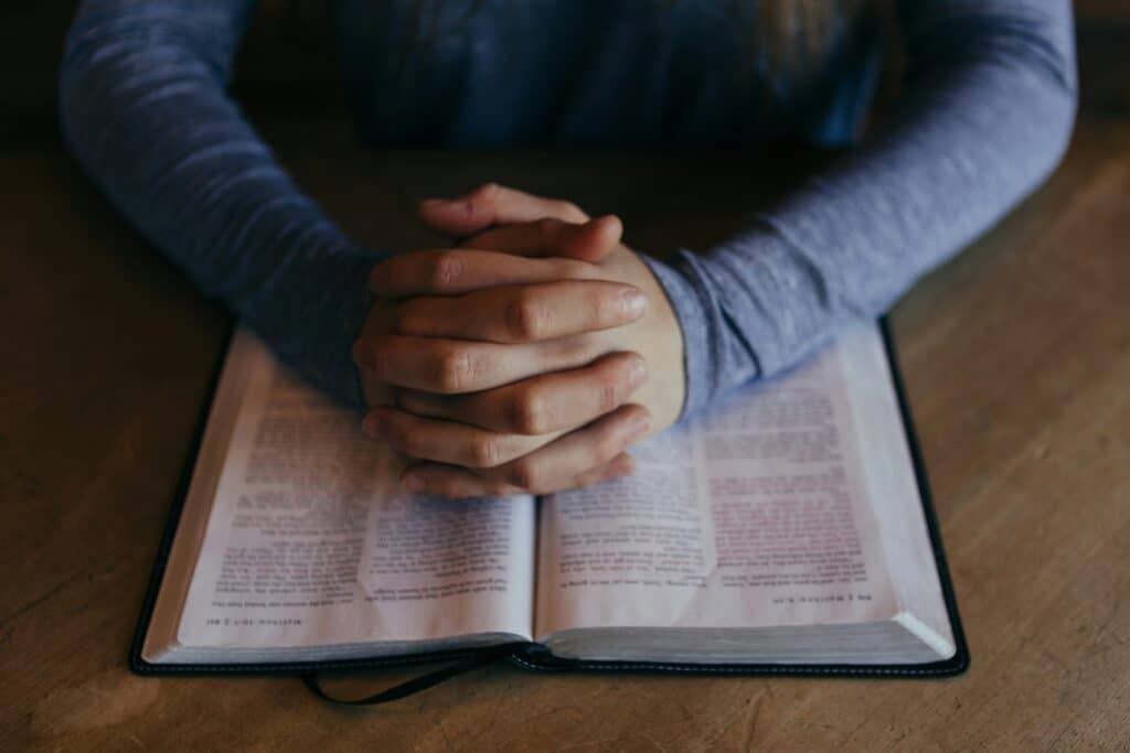 person praying with bible