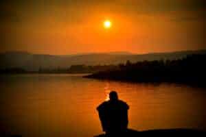 person sitting alone at the lake