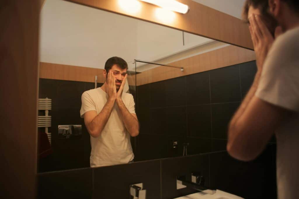 man looking in mirror scared