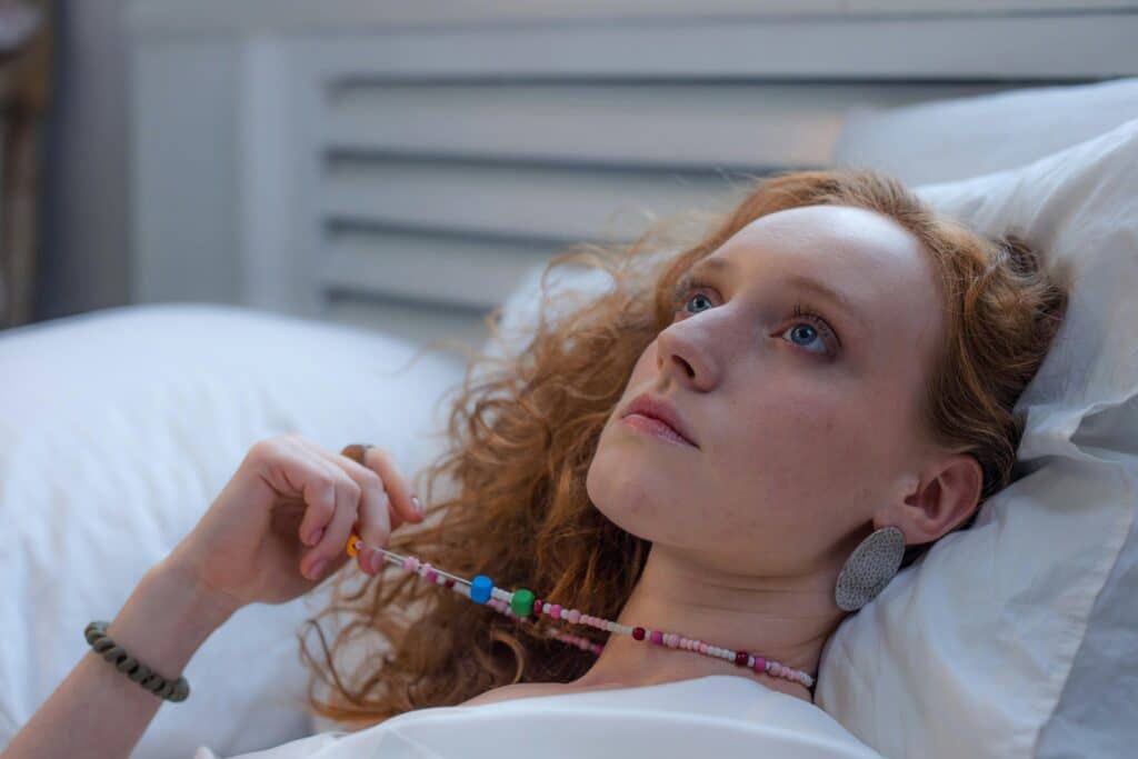 woman laying in bed looking at ceiling