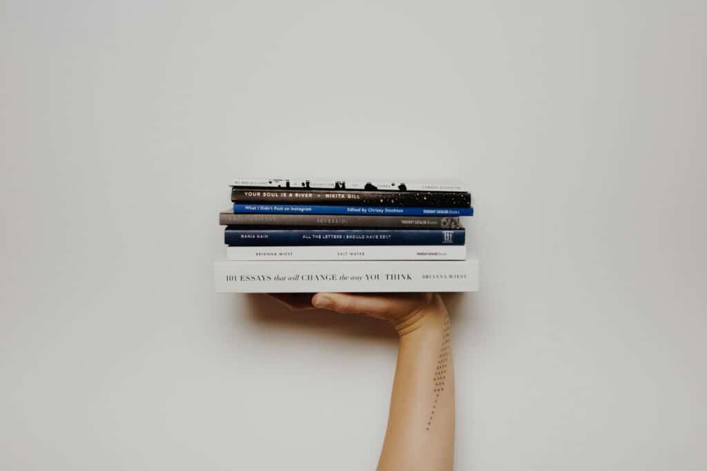 person holding a stack of books