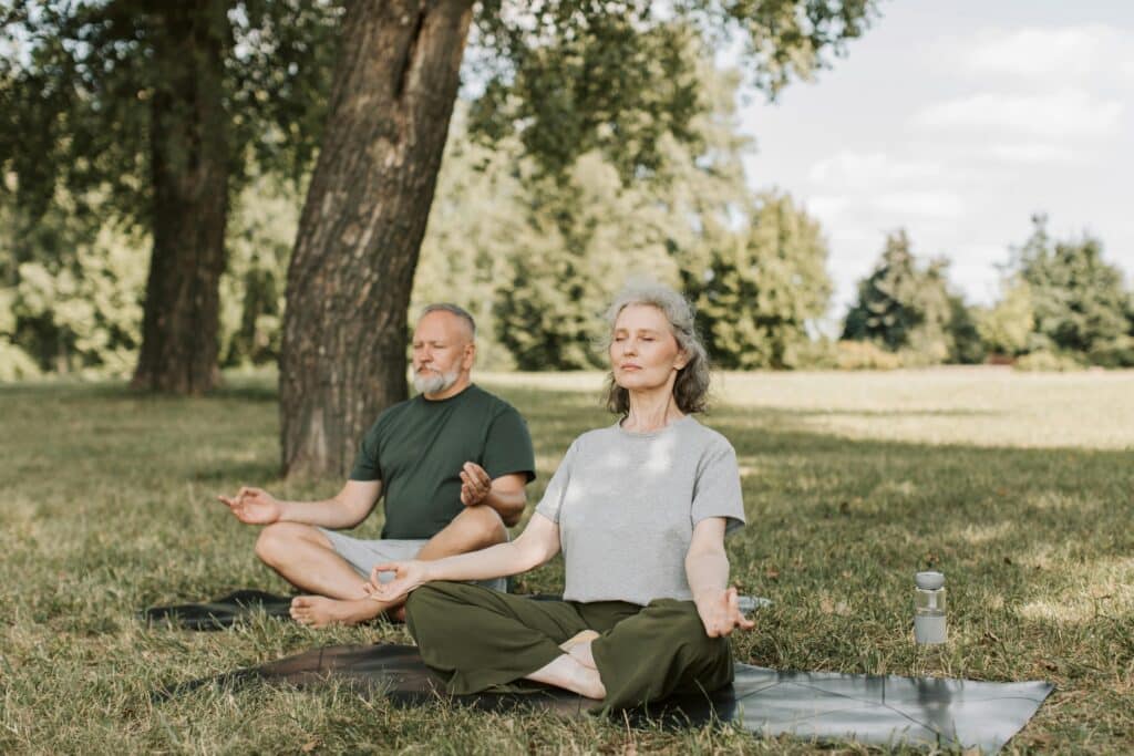 older people meditating outside together