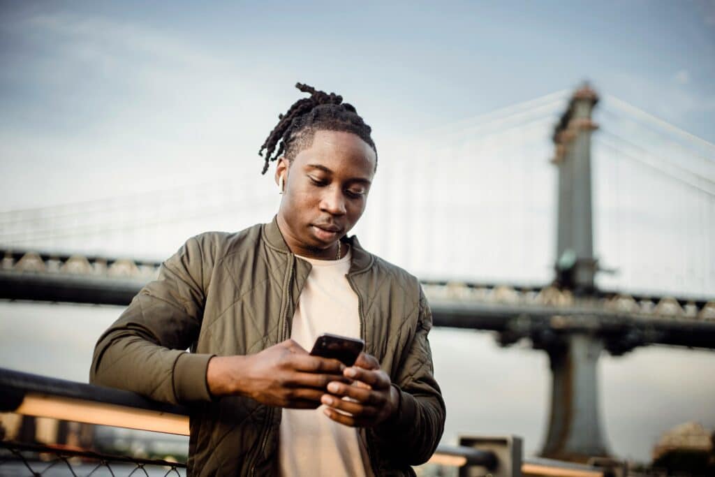 man scrolling on phone outside