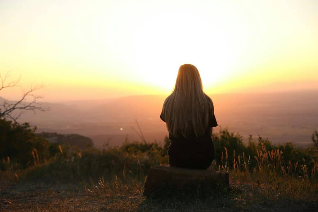 woman outside looking at sunset