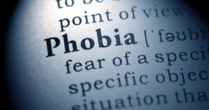 Close-up of a dictionary page highlighting the word'Phobia' and its definition: 'fear of a specific object or situation'.