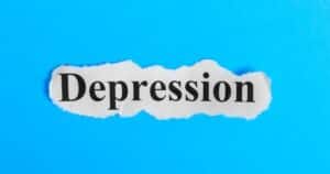 Torn piece of white paper with the word 'Depression' on a bright blue background.