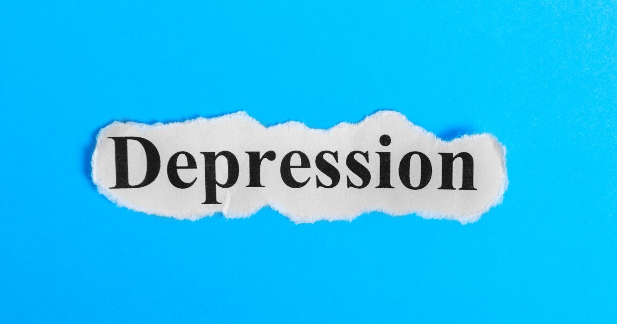 Torn piece of white paper with the word'Depression' on a bright blue background.