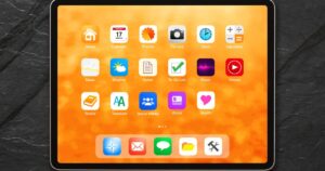 Tablet home screen on an orange background with app icons like Home, Calendar, Photos, Camera, Clock, Calculator, Maps, Weather, Notes, To-Do List, Music, Videos, Books, Translate, Social Media, Wallet, Health, plus a bottom dock of apps.