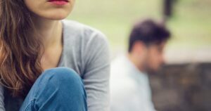 - Treat Mental Health Tennessee Close-up of a woman with brown hair and pink lips sitting outdoors in the foreground; a blurred man sits in the background.